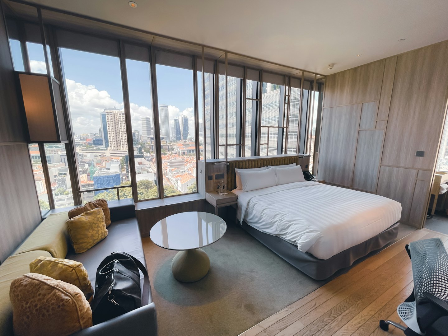 Habitación de hotel moderna con vistas a un ajetreado horizonte urbano.